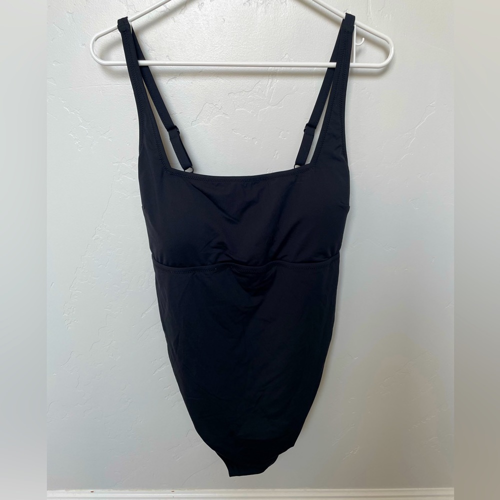 Black strappy one piece swimsuit with tie in the back.